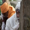 An old man looking curiously beging a pillar