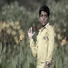A boy posing for photograph in a park