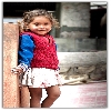 Poor Kid with a nice smile posing for photograph
