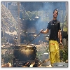 person preparing food in an open ground near a temple