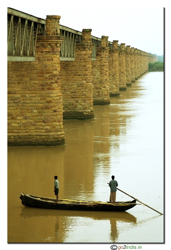 Down the old bridge at river Godavari people in boat