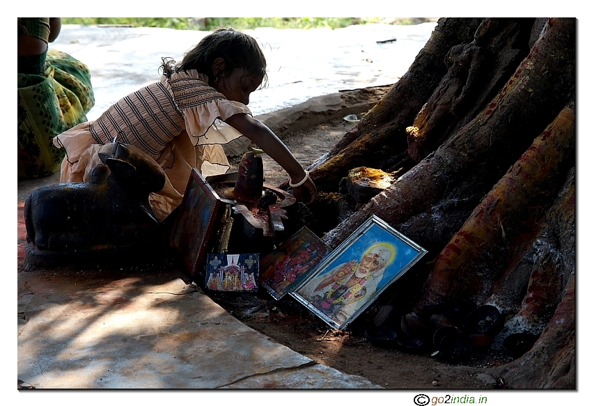 girl performing Sai Ram pooja near tree