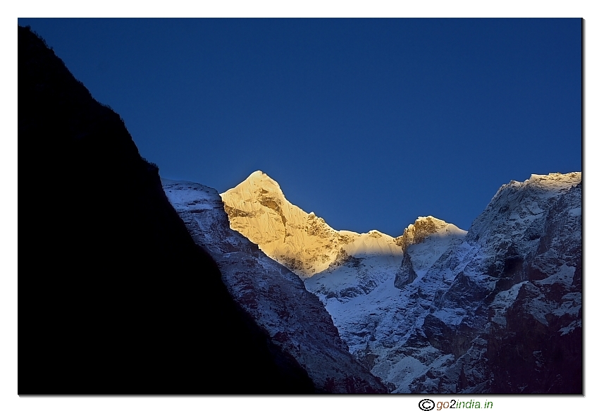 Golden color at morning of Neelkanth peak behind Nara Hill at Badrinath Dham